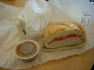 Turkey and swiss on a roll with honey mustard sauce on the side.