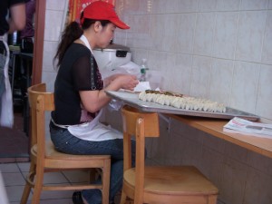 Woman hand making rows upon rows of dumplings