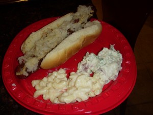 Hot dog with sauerkraut, macaroni salad, and potato salad