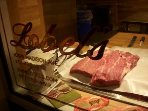 Beautiful pieces of raw beef behind the glass at Lobel's