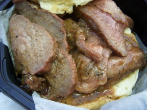 Close up on the beef and all the gravy soaking into the bottom bun