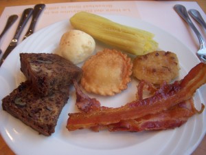 Banana bread, pan de yuca, sweet corn tamale, chicken empanada, some sort of fritter stuffed with cheese, and bacon