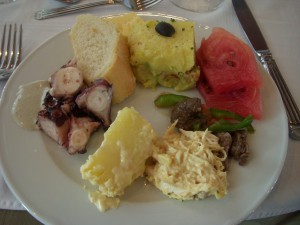 Octopus, crusty french bread, some sort of potato thing with guacamole, watermelon, beef with peppers, chicken stew, yuca
