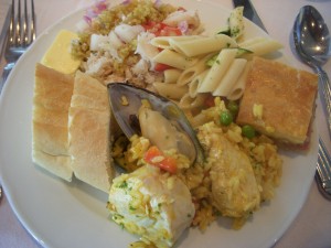Paella with seafood and meat, french bread, crab salad with quinoa, pasta salad, ham and cheese tart
