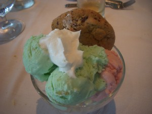 Pistachio and strawberry ice cream with a chocolate chip cookie and whipped cream