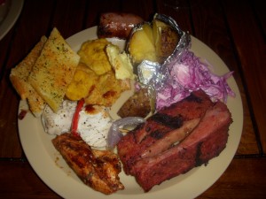 BBQ ribs, BBQ chicken, fish kebabs, garlic bread, fried green plantains, sausage, baked potato, cole slaw