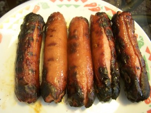 Hot dogs covered in a spicy chili sauce and then grilled