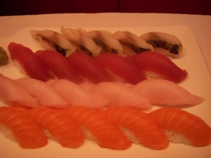 Mackerel on top, followed by tuna, yellowtail, and salmon sushi
