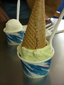 Pistachio gelato in a cup with a cone on top