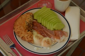 Sous vide eggs, half an everything bialy, honeydew, and prosciutto, plus coffee and a mimosa