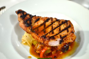 Char grilled "prime" pork chop with pepperade, sausage, snap beans, and goat cheese napoleon