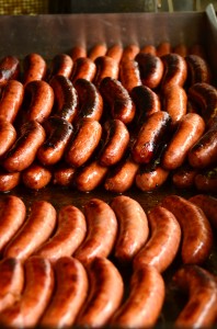 Half smokes piled up on the griddle