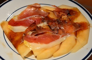 Slices of crenshaw melon with prosciutto and balsamic syrup