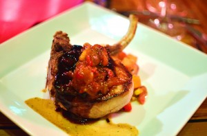 Fennel brined pork chop with sweet potato and corn hash, green tomato peach chutney, and red eye gravy